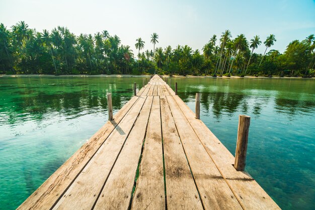 Puente de madera o muelle en la playa y el mar.