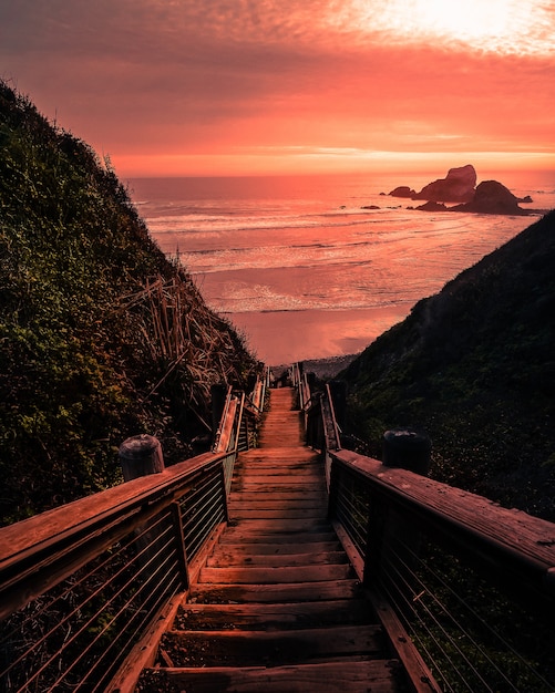 Foto gratuita puente de madera a la playa durante la puesta de sol