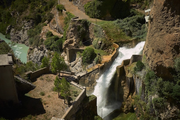 Puente sobre una cascada entre verdes colinas