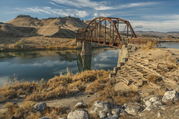 Puente sobre el río en medio de montañas y cielo azul