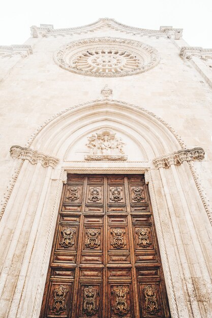 Puerta de madera marrón en edificio de hormigón blanco