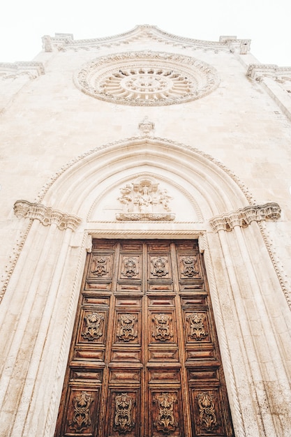 Puerta de madera marrón en edificio de hormigón blanco