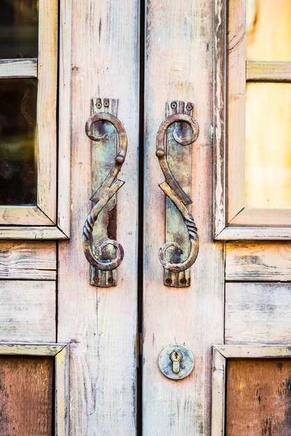 Puerta de madera con pomos oxidados