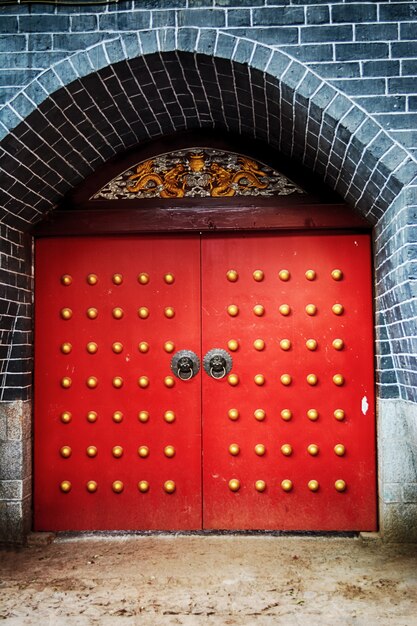 Puerta roja con decoración de botones dorados