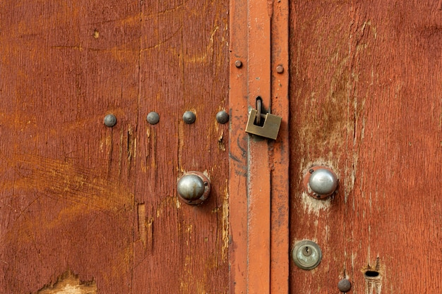 Puertas de madera envejecidas con remaches y cerradura de metal.