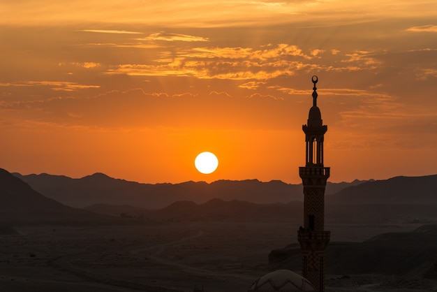 Puesta de sol con mezquita musulmana en primer plano