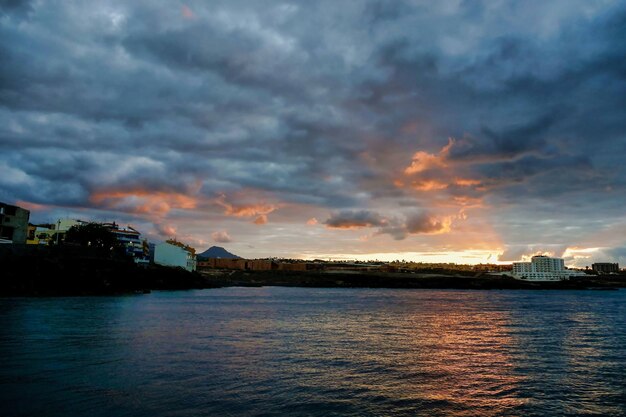 Puesta de sol sobre el agua bajo un cielo nublado en las Islas Canarias, España