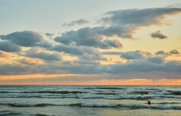 Puesta de sol sobre el mar con nubes de colores, luz solar naranja, puestas de sol de otoño, temporada de terciopelo de otoño temprano, la idea de un fondo o una pantalla de inicio