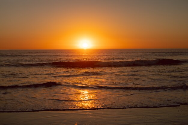 Puesta de sol sobre el mar en la playa