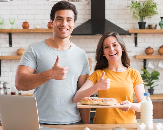 Pulgares arriba gesto pareja cocinar un pan