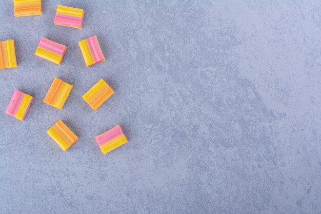 Puñado de chicles de naranja esparcidos sobre la superficie de mármol