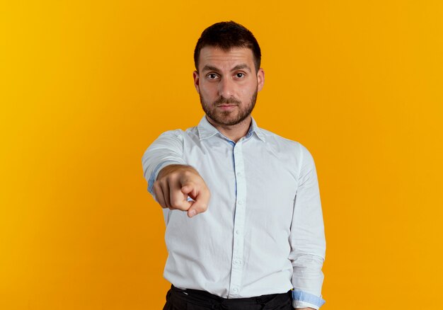 Puntos de hombre guapo confiado aislados en la pared naranja