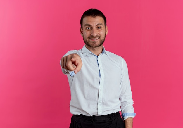 Foto gratuita puntos de hombre guapo sonriente aislados en la pared rosa