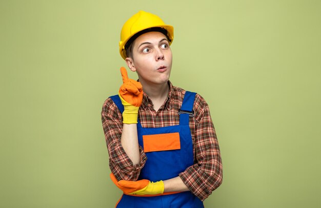 Puntos impresos en el constructor masculino joven vistiendo uniforme con guantes