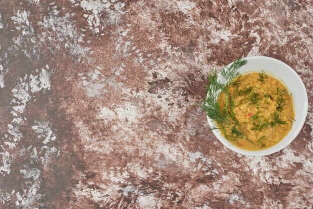 Puré de sopa con hierbas en una taza, vista superior.