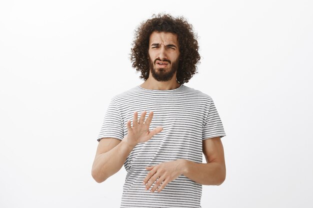 Qué y horrible idea, no. Retrato de modelo masculino guapo disgustado disgustado con barba y peinado afro, agitando la palma en la parada o gesto suficiente, frunciendo el ceño por la aversión