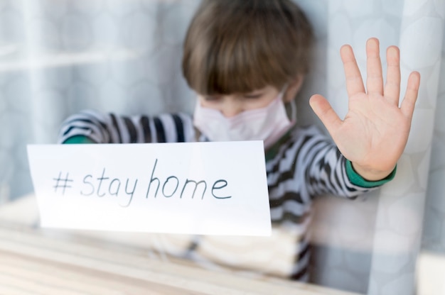 Quedarse en casa niño con una máscara