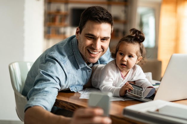 Quedarse en casa padre divirtiéndose mientras trabaja en casa y tomando selfie con su niña