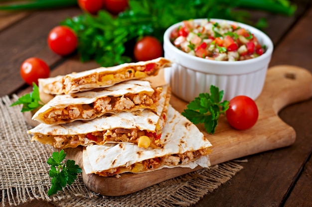 Quesadilla mexicana envuelta con pollo, maíz y pimiento y salsa