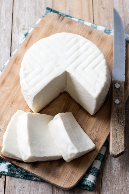 Queso blanco fresco en rodajas de leche de vaca sobre mesa de madera