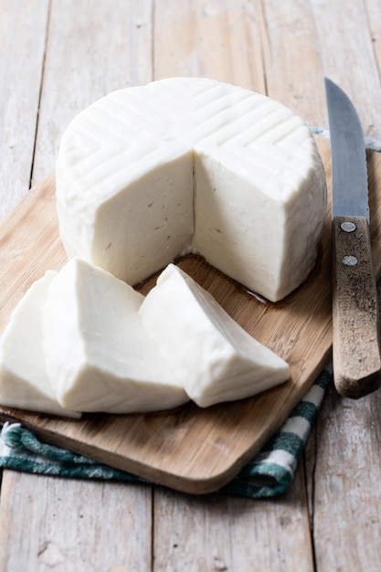 Foto gratuita queso blanco fresco en rodajas de leche de vaca sobre mesa de madera