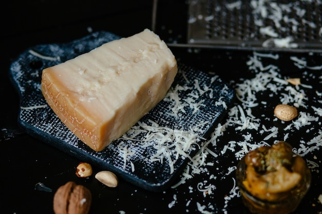 Queso parmesano. Queso parmesano rallado italiano en la tabla de cortar