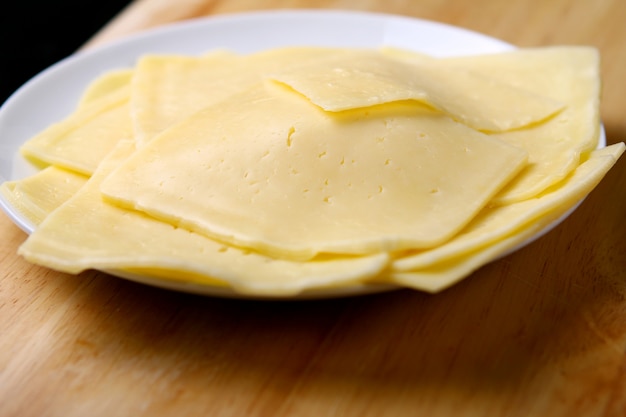 Foto gratuita queso rebanado en mesa de madera