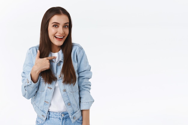 Quién yo Linda mujer morena joven y coqueta apuntándose a sí misma y sonriendo risita coqueta siendo elegida pidiendo participar fue elegida o promovida alardeando de sus propios logros