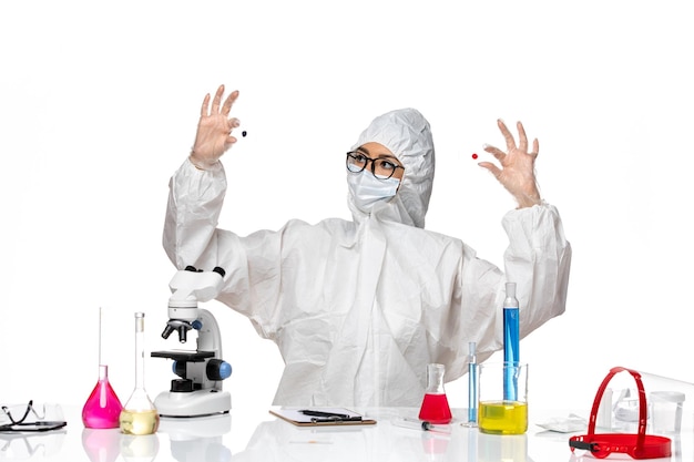 Foto gratuita química de vista frontal en traje de protección especial sosteniendo muestras sobre fondo blanco claro química del virus salud de la pandemia de covid