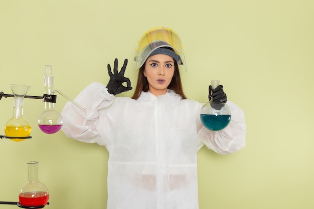 Foto gratuita químico femenino de vista frontal en traje de protección especial que trabaja con soluciones en el escritorio verde