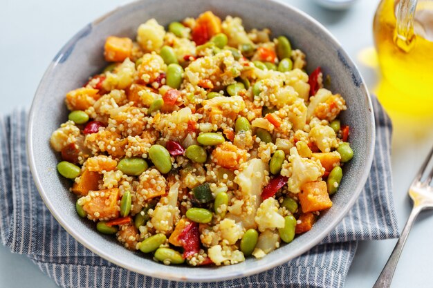 Quinua con verduras cocinadas para el almuerzo o la cena y servidas en un tazón. De cerca.