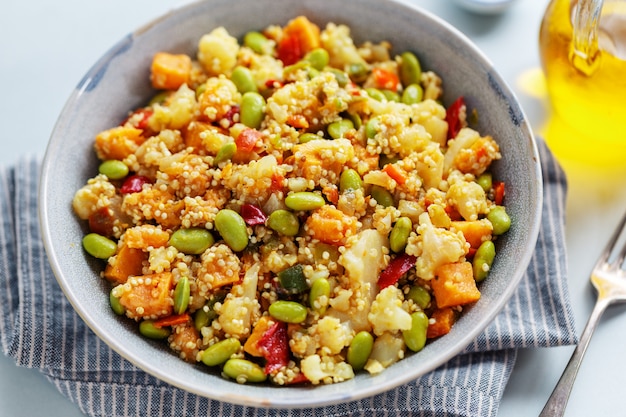 Quinua con verduras cocinadas para el almuerzo o la cena y servidas en un tazón. De cerca.