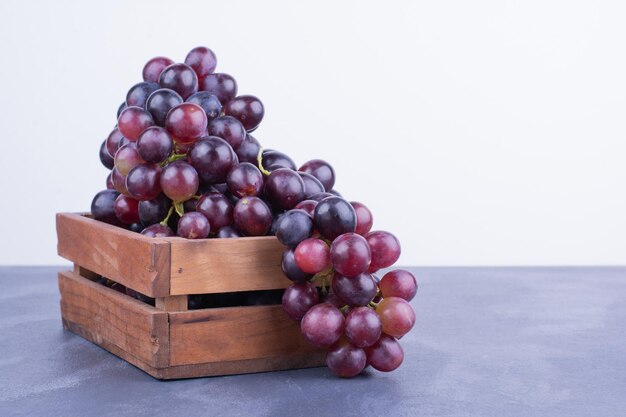 Un racimo de uvas en una bandeja de madera.