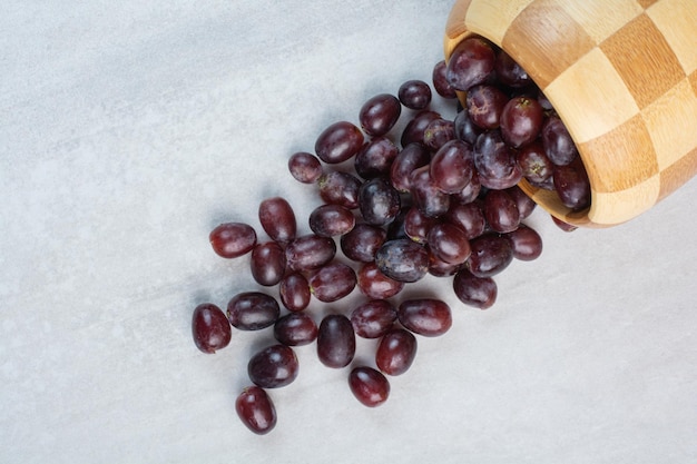 Racimo de uvas moradas frescas fuera del cubo. Foto de alta calidad