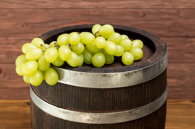 Foto gratuita racimo de uvas sobre barril de madera