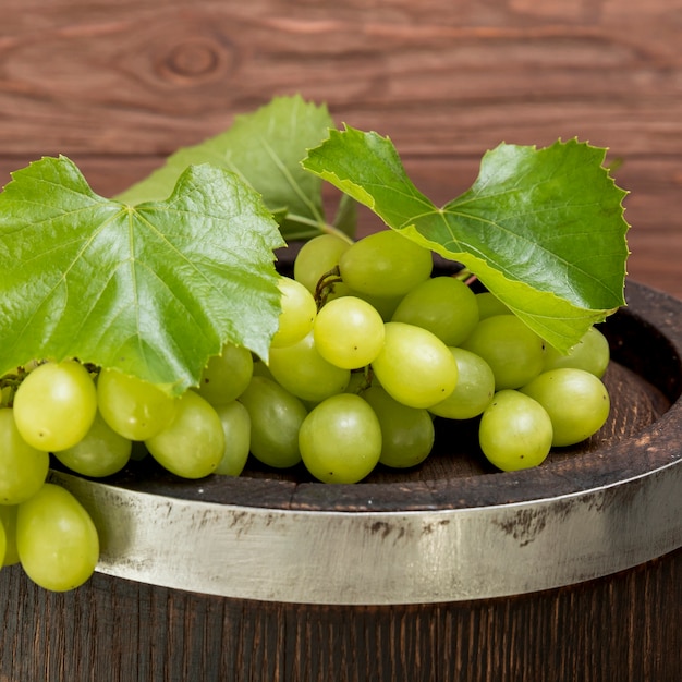 Racimo de uvas sobre barril de madera