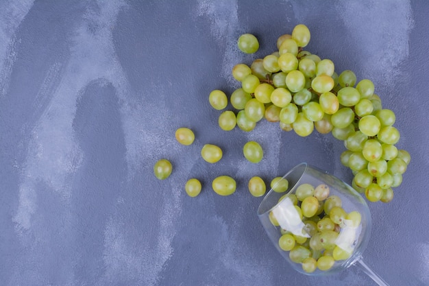 Foto gratuita racimo de uvas verdes aisladas en azul.