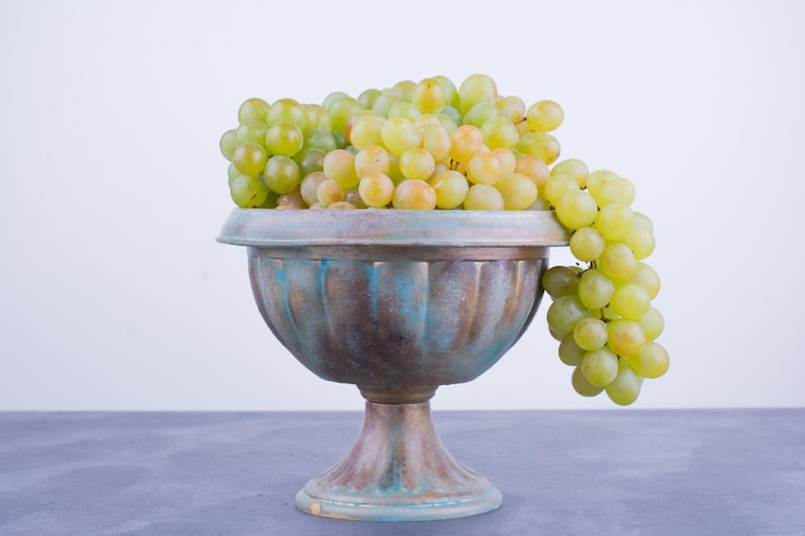 Foto gratuito un racimo de uvas verdes en una olla metálica.