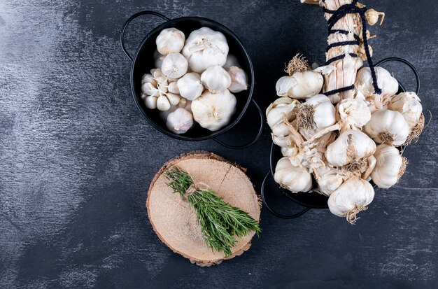 Racimos de ajo y romero con un poco en una vista superior del cubo