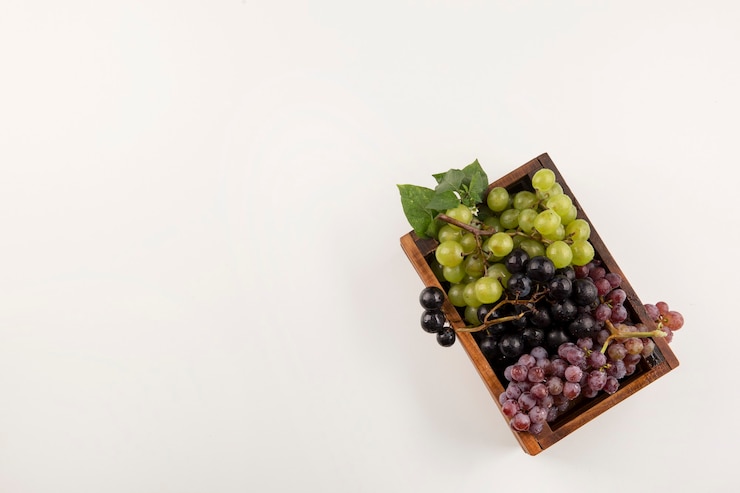 Foto gratuito racimos de uva verde y roja en una caja de madera en la parte inferior