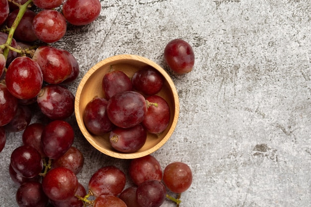 Racimos de uvas rojas maduras frescas sobre la superficie oscura.