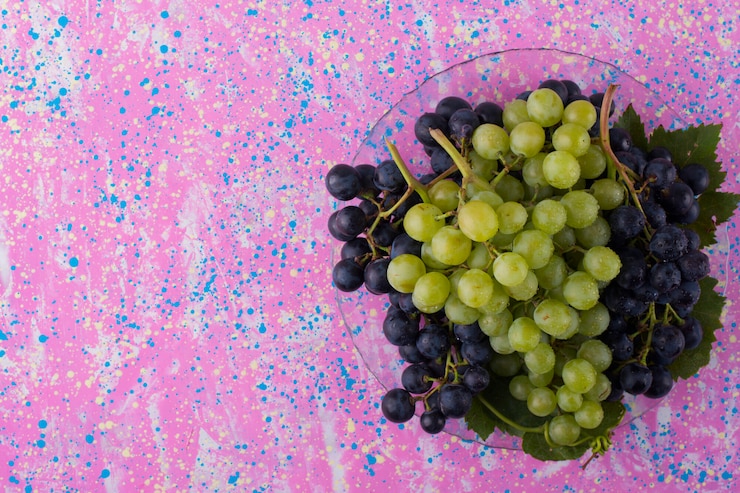 Foto gratuito racimos de uvas rojas y verdes en un plato