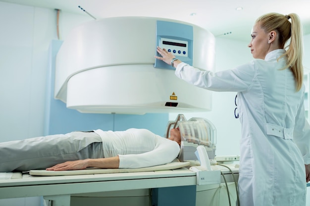 Radiólogo ajustando el escáner de resonancia magnética antes del examen médico de un paciente al que se le realiza una exploración cerebral en el hospital