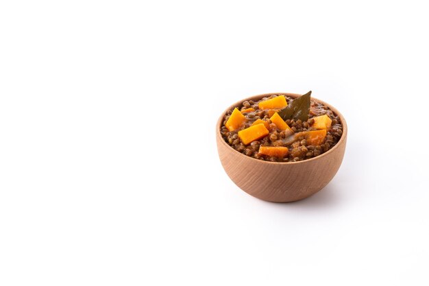 Ragout de estofado de lentejas con calabaza y zanahoria en un recipiente aislado sobre fondo blanco