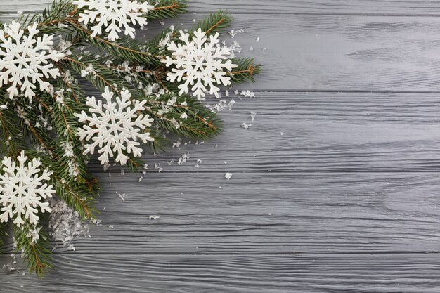 Rama de abeto con adornos de nieve y copos de nieve de papel