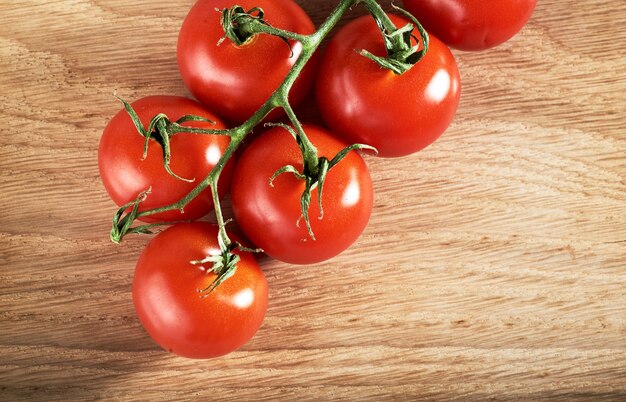 Rama de tomates cherry rojos de madera orgánica.