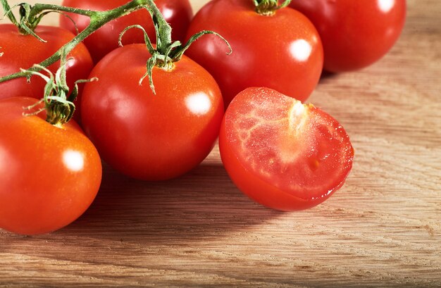 Rama de tomates cherry rojos de madera orgánica.