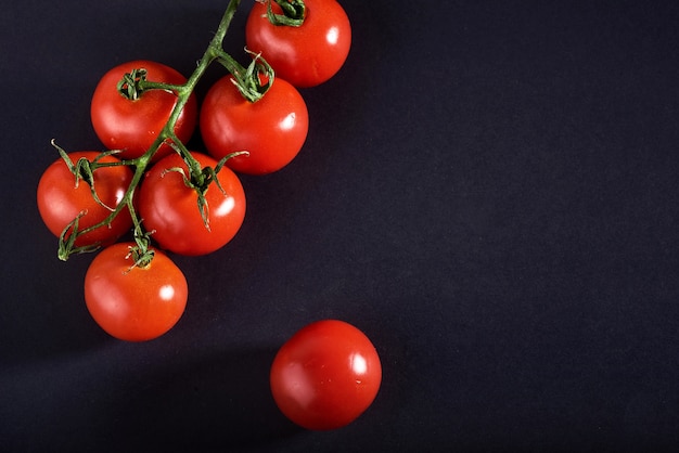 Foto gratuita rama de tomates orgánicos rojos sobre un negro