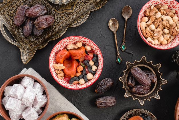 Ramadán jugosas dátiles y frutos secos; nueces y lukum sobre fondo negro