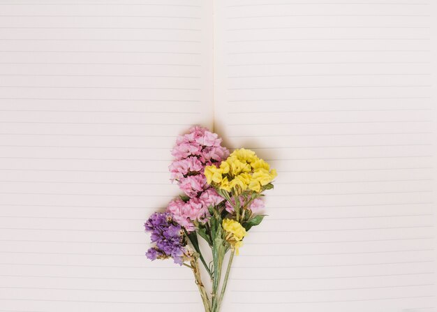 Ramas de flores pequeñas en cuaderno en blanco